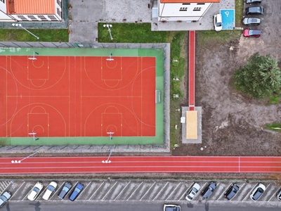 Widok z drona pokazujący boisko sportowe, skocznie w dal i bieżnię