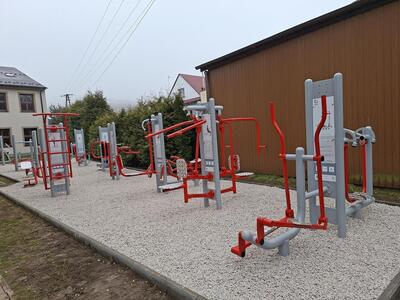 Urządzenia siłowni zewnętrznej na kamienistym podłożu, w tle budynki