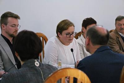 Nowa Radna Katarzyna Magdziarz, siedząca przy stole wśród Radnych.