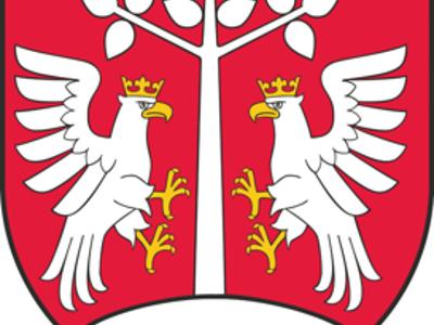 Herb powiatu myślenickiego: dwa białe orły w koronach po bokach białego drzewa na czerwonym tle, u dołu biały półokrąg.
