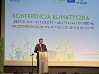 Zdjęcie z konferencji klimatycznej „Bezpieczna przyszłość – adaptacja i ochrona przeciwpowodziowa w obliczu zmian klimatu”, mówca przy mównicy.
