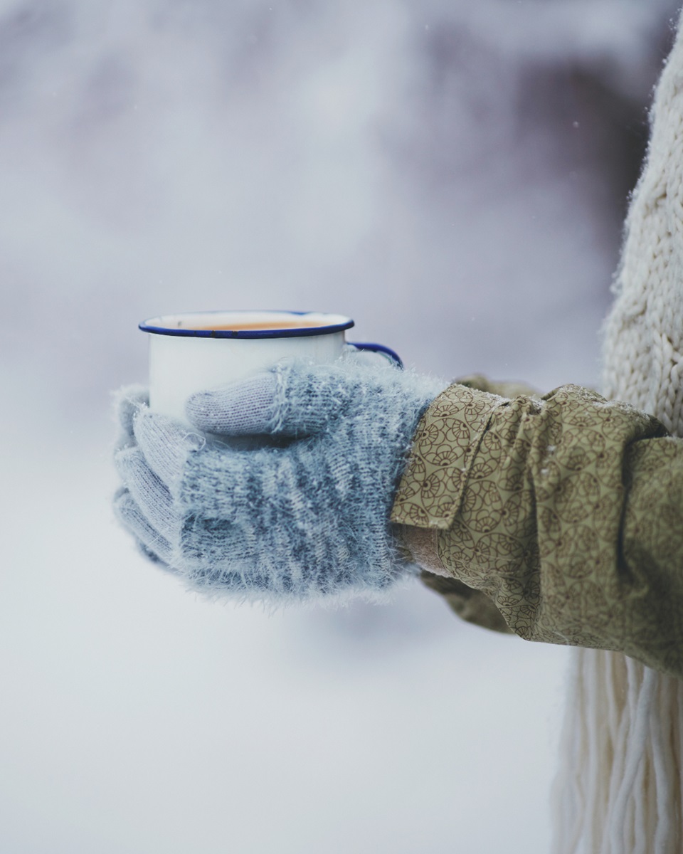 Na zdjęciu widoczny jest kubek trzymany na tle śniegu