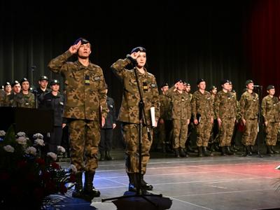 Na zdjęciu uczniowie klas mundurowych ZS Dobczyce podczas uroczystego meldunku na scenie akademii.