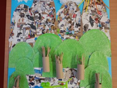 Praca przedstawiający góry, drzewa, chmury, słońce i rower wykonana z surowców wtórnych