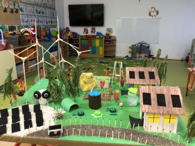 Makieta z domami, ogrodem i wiatrakami z zapałek, papieru i plastikowych elementów