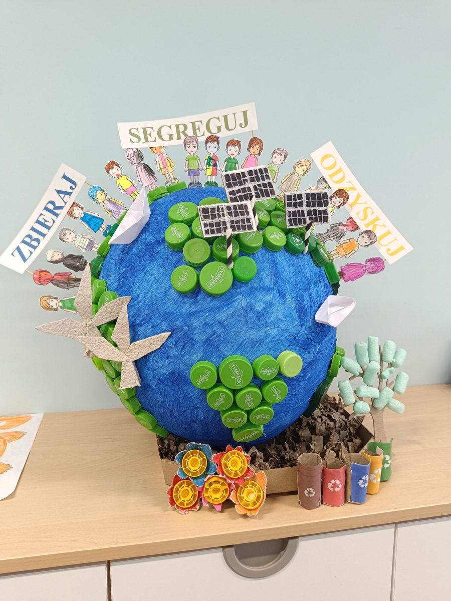 Kula ziemska z dziećmi, kontynentami z zakrętek i przykładami OZE oraz hasłami: zbieraj, segreguj, odzyskuj