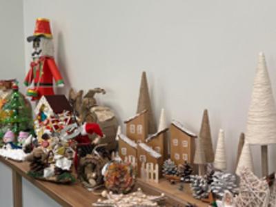 Szafka z ułożony na niej ozdobami świątecznymi ze sznurka, drewna szyszek i surowców wtórnych