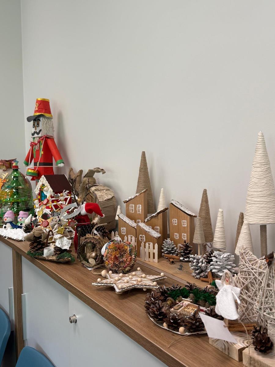 Szafka z ułożony na niej ozdobami świątecznymi ze sznurka, drewna szyszek i surowców wtórnych 