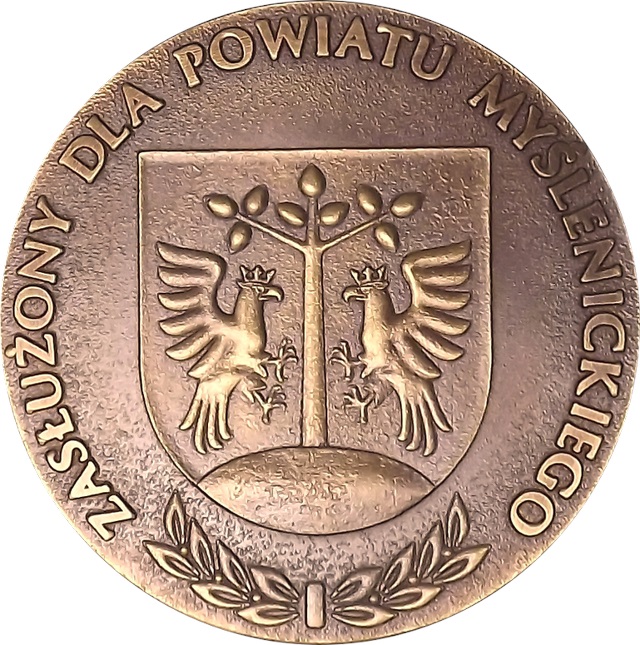 Logo z napisem: Zasłużony dla Powiatu Myślenickiego