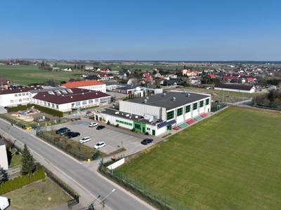 Widok na kompleks budynków sportowych, szkoły podstawowej, przedszkola, żłobka, biblioteki oraz astrobazy w Gostycynie.