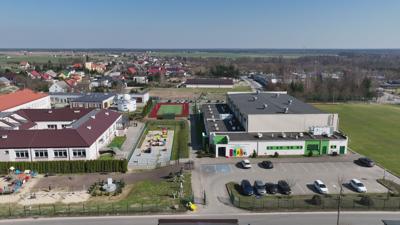 Widok na kompleks budynków sportowych, szkoły podstawowej, przedszkola, żłobka, biblioteki oraz astrobazy w Gostycynie.
