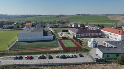 Widok na kompleks budynków sportowych, szkoły podstawowej, przedszkola, żłobka, biblioteki oraz astrobazy w Gostycynie.