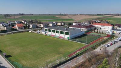 Widok na kompleks budynków sportowych, szkoły podstawowej, przedszkola, żłobka, biblioteki oraz astrobazy w Gostycynie.