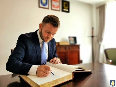 Na zdjeciu Ryszard Świlski wpisujący się do pamiątkowej księgi Gminy Pelplin 