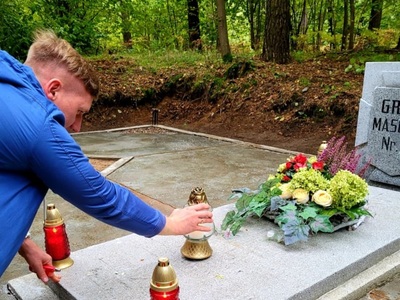 zdjęcie przedstawiajace sprzatanie grobów w lesie szpęgawskim 