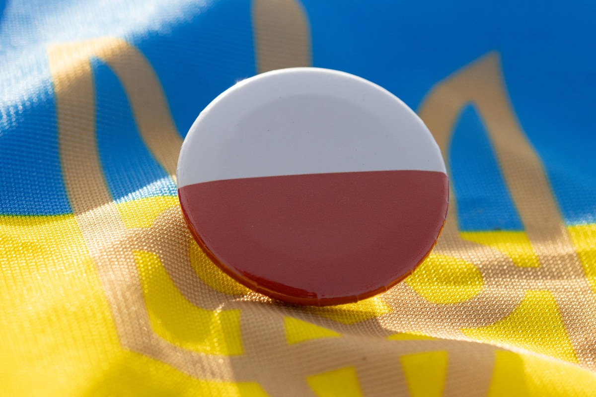 przypinka z flagą Polski na tle flagi Ukrainy