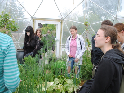 Zdjęcie przedstawia uczestników wyjazdu oraz permakulturę w kopule