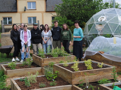 Zdjęcie prezentuje uczestników wyjazdu oraz podwyższone grządki