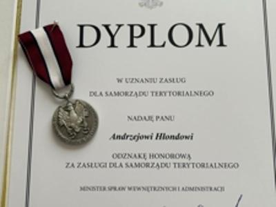 Zdjęcie prezentuje dyplom i medal "W uznaniu zasług dla samorządu terytorialnego".