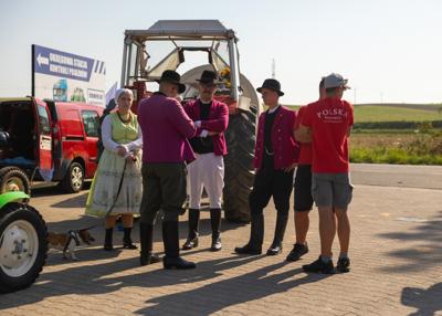Na zdjeciu parada zabytkowych aut i traktorów, wraz z uczestnikami