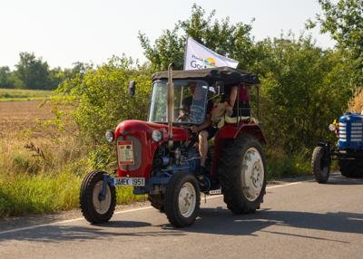 Zabytkowy traktor z flagą z logo powiatu