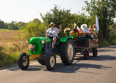Zabytkowy traktor, przyczepa i uczestnicy rajdu