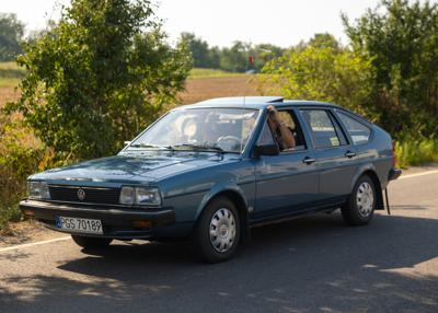 Zabytkowy samochód i uczestnicy rajdu