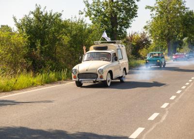 Zabytkowy samochód i uczestnicy rajdu