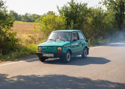 Zabytkowy samochód i uczestnicy rajdu