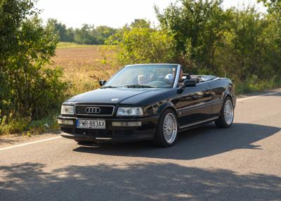 Zabytkowy samochód i uczestnicy rajdu