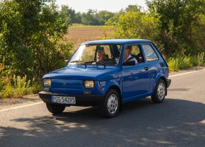 Zabytkowy samochód i uczestnicy rajdu