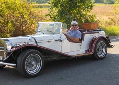 Zabytkowy samochód i uczestnicy rajdu