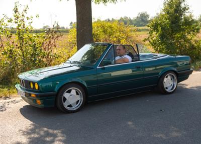 Zabytkowy samochód i uczestnicy rajdu