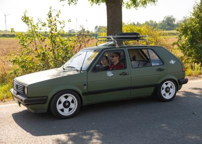 Zabytkowy samochód i uczestnicy rajdu