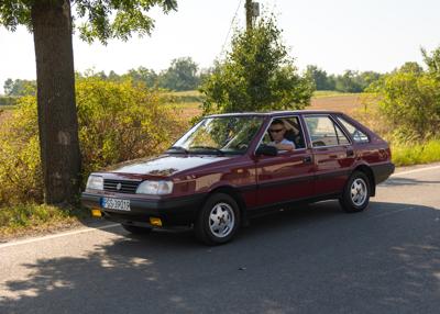 Zabytkowy samochód i uczestnicy rajdu