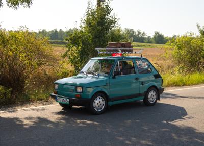 Zabytkowy samochód i uczestnicy rajdu