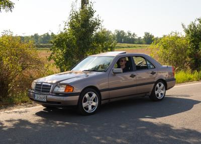 Zabytkowy samochód i uczestnicy rajdu