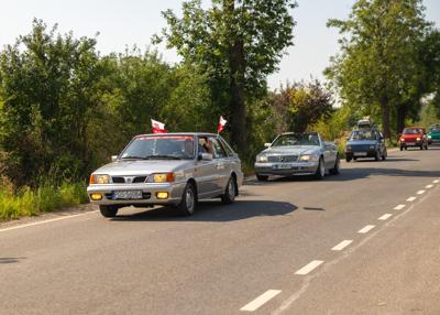 Zabytkowy samochód i uczestnicy rajdu