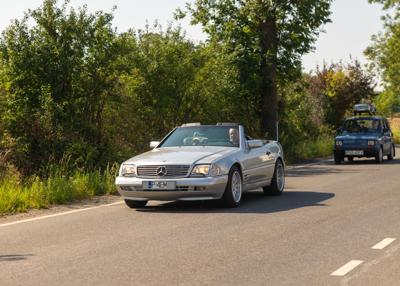 Zabytkowy samochód i uczestnicy rajdu