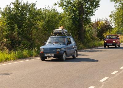 Zabytkowy samochód i uczestnicy rajdu