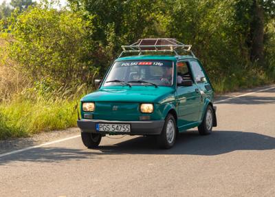 Zabytkowy samochód i uczestnicy rajdu