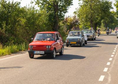 Zabytkowy samochód i uczestnicy rajdu