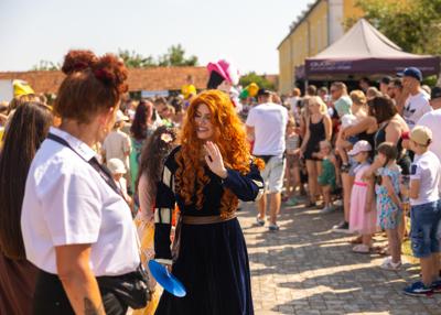 Na zdjęciu widać postacie bajkowe w tle mieszkańcy