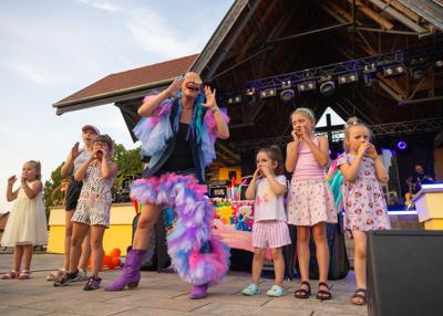 Na zdjęciu scena,występująca Patrycja Lipińska z młodą grupą widzów i balonowe show
