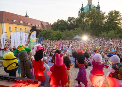 Na zdjęciu scena, na której znajdują się bajkowe postacie w tle uczestnicy wydarzenia