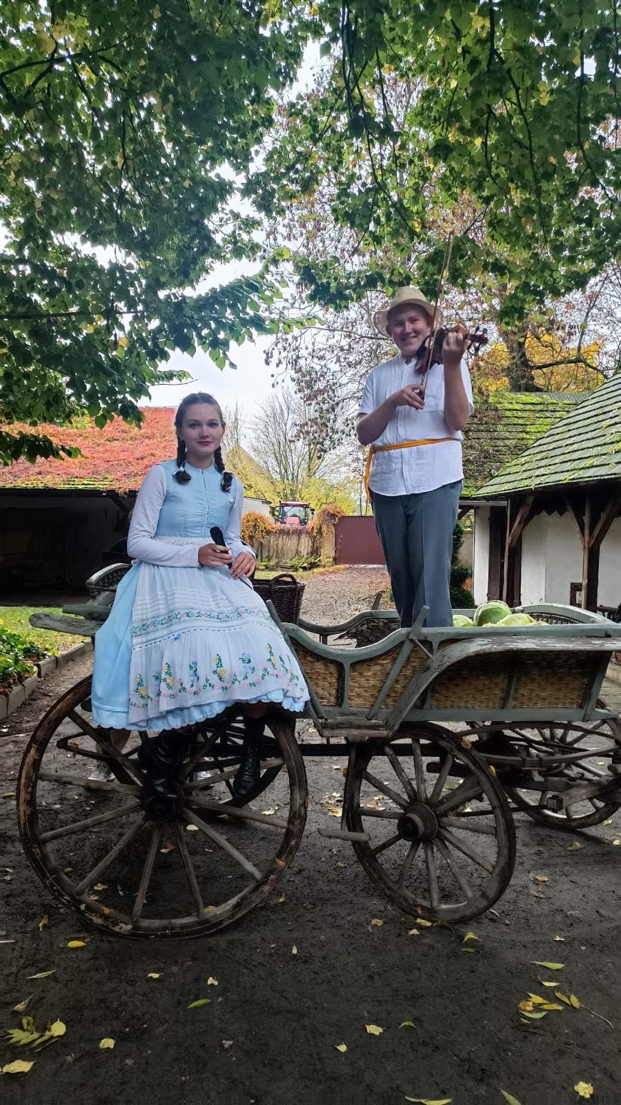 Zdjęcie przedstawia uczniów w strojach ludowych na wozie.