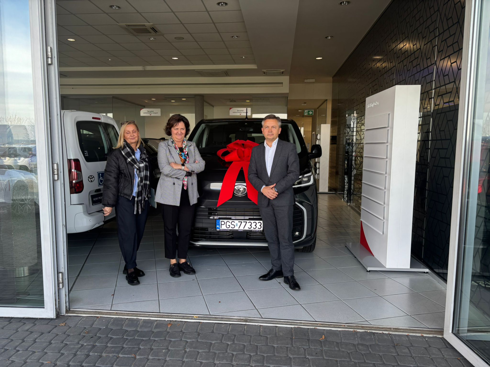 zdjęcie przedsyawiaq nowe auto firmy Toyota, dyrektorkę deomu dziecka, starostę gostyńskiego oraz przedstawicielkę firmy Toyota