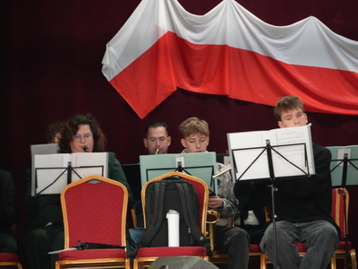 Koncert z okazji 106 rocznicy odzyskania Niepodległości Muzycy orkiestry dętej podczas występu na tle flagi Polski.