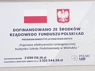 Tablica informacyjna o dofinansowaniu z Polskiego Ładu na termomodernizację szkoły w Warlubiu