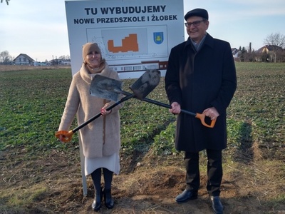 symboliczne posadowienie tablicy informacyjnej - Wójt Gminy i Przewodnicząca Rady Gminy zdjęcie przed tablica informacyjną